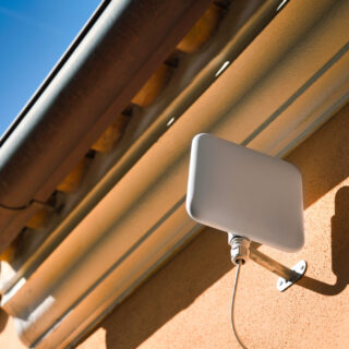 5G Fixed Wireless Access antenna hanging on the wall outside the house